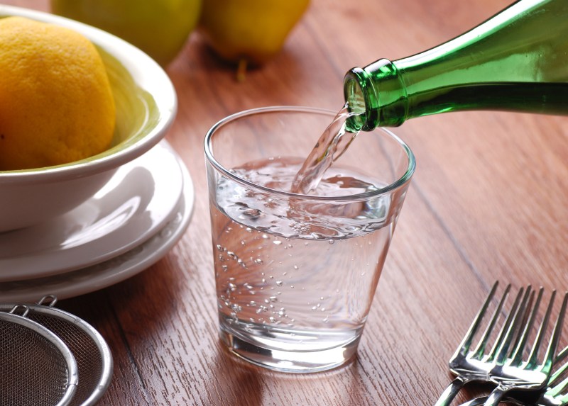 bootle of mineral water porring in a glass