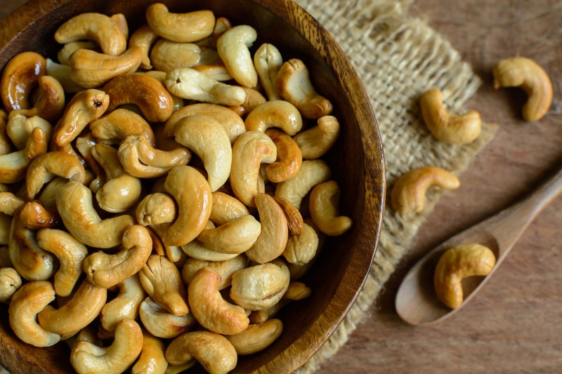 cashew nuts with wooden spoon on sackcloth, Top view