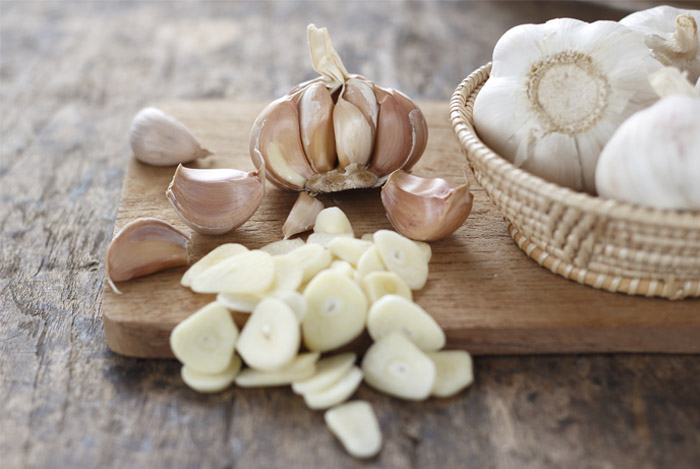 garlic cloves on table - 14 GEZONDE EIGENSCHAPPEN VAN KNOFLOOK