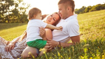 Family with one baby playing in the park