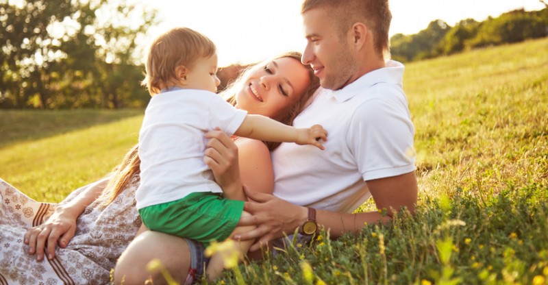 Family with one baby playing in the park