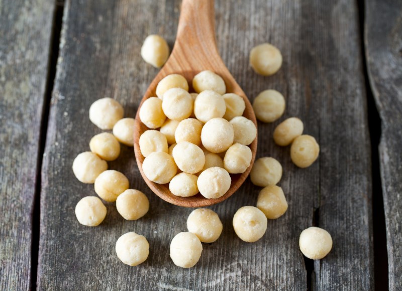 salted macadamia nuts on wooden surface