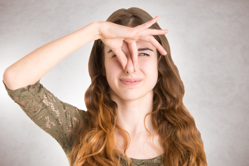 woman closing her nose