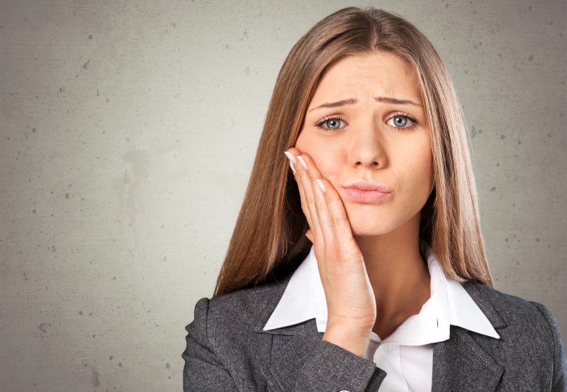 woman suffering with tooth pain